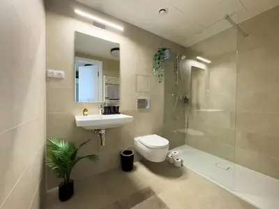 a bathroom with a toilet and a sink and a shower at Central Riverside Apartment - Free Parking in Prague