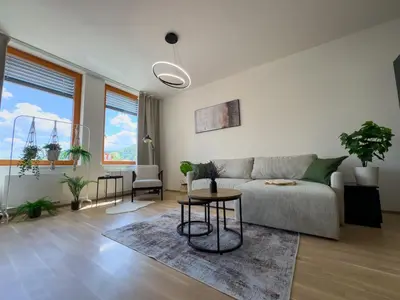 a living room with a couch and a table at Central Riverside Apartment - Free Parking in Prague