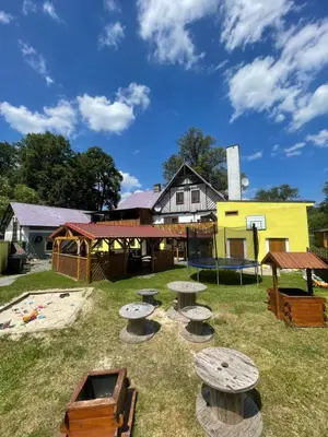 a yard with picnic tables and a building at Penzion Černý Mlýn in Dubá