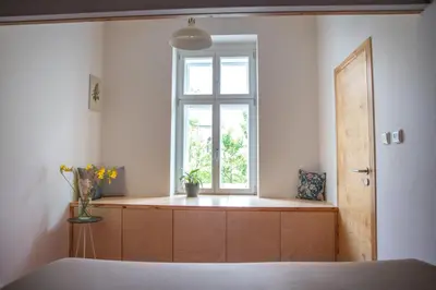 a bedroom with a window and a wooden cabinet at Chaloupka Křivoklát in Křivoklát