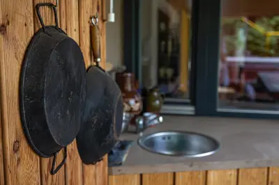 two frying pans hanging on a wall next to a sink at Chaloupka Křivoklát in Křivoklát