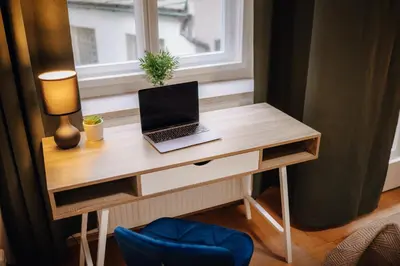 a desk with a laptop on it next to a window at 3B Bright Beautiful Newly Renovated 3BR in Prague