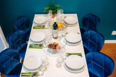 a table with glasses and plates and a bottle of wine at 3B Bright Beautiful Newly Renovated 3BR in Prague