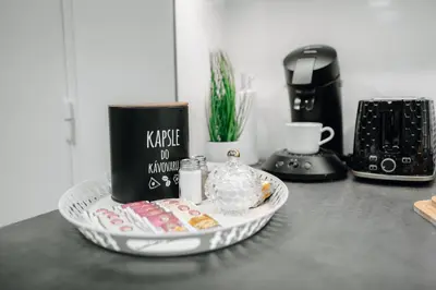 a table with a plate with a coffee maker and a coffee pot at 3B Bright Beautiful Newly Renovated 3BR in Prague