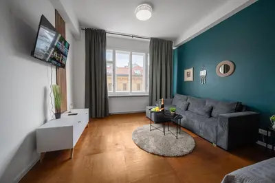 a living room with a couch and a tv at 3B Bright Beautiful Newly Renovated 3BR in Prague