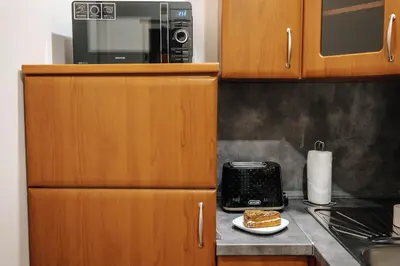 a kitchen with a microwave and a plate of food at Cityscape Charm Spacious 3 Bedroom Haven for 7 in Prague