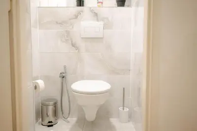 a bathroom with a white toilet in a room at Cityscape Charm Spacious 3 Bedroom Haven for 7 in Prague