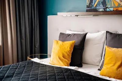 a bedroom with a bed with yellow pillows at Heritage Haven Charming 3BR City Center in Prague
