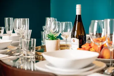 a table with glasses and a bottle of wine at Heritage Haven Charming 3BR City Center in Prague