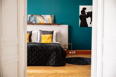 a bedroom with a bed and a blue wall at Heritage Haven Charming 3BR City Center in Prague