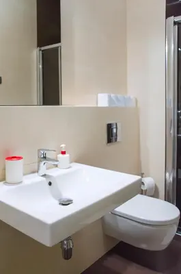 a bathroom with a white sink and a toilet at Modern Apartment Všehrdova in Prague