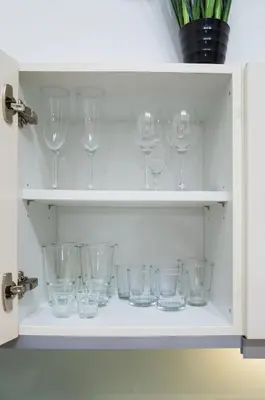 a cupboard filled with empty wine glasses at Modern Apartment Všehrdova in Prague