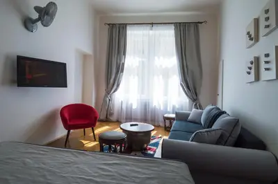 a living room with a blue couch and a red chair at Design Apartment Havelska in Prague