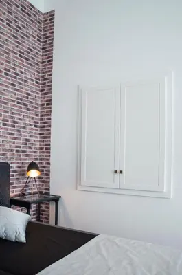 a bedroom with a bed and a brick wall at Design Apartment Havelska in Prague