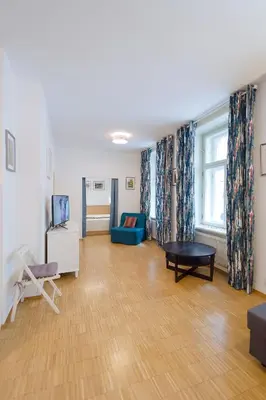 a living room with a blue couch and a table at Modern Apartment Charvátova in Prague