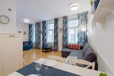 a living room with a couch and a table at Modern Apartment Charvátova in Prague