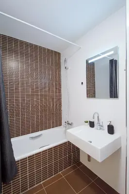 a bathroom with a sink and a tub and a mirror at Modern Apartment Charvátova in Prague