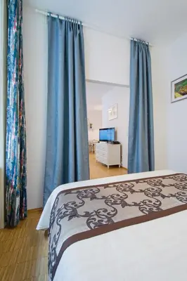 a bedroom with a bed with blue curtains at Modern Apartment Charvátova in Prague