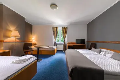 a hotel room with two beds and a desk at Prague Hotel Carl Inn restaurant & Free Parking in Prague