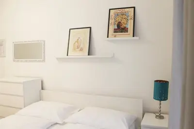 a white bedroom with a bed and two pictures on the wall at Modern Apartment Ve Smečkách 28 in Prague