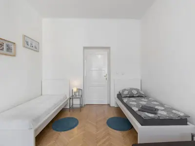 a white room with a bed and a blue rug at Apartment Old Town home-3 by Interhome in Prague