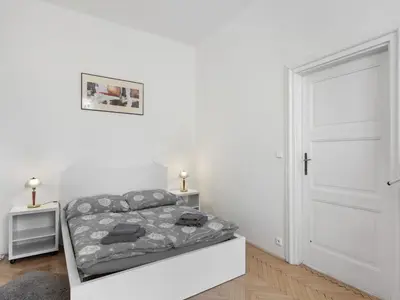 a white bedroom with a bed and a white door at Apartment Old Town home-3 by Interhome in Prague