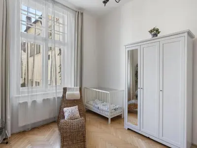 a white room with a crib and a cabinet at Apartment Old Town home-3 by Interhome in Prague