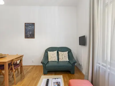 a living room with a green chair and a table at Apartment Old Town home-2 by Interhome in Prague