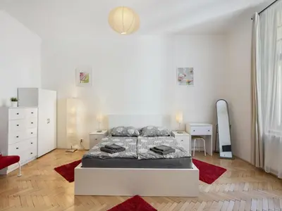 a white bedroom with a bed and a red rug at Apartment Old Town home-2 by Interhome in Prague
