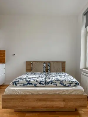 a bed with a wooden frame in a bedroom at National Museum View Studio in Prague