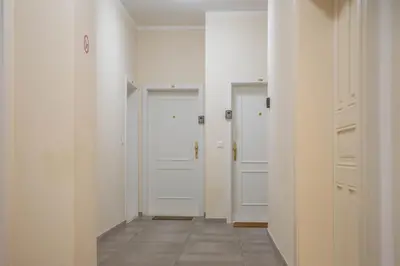 a hallway with two white doors and a tile floor at National Museum View Studio in Prague