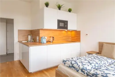 a small kitchen with white cabinets and a microwave at National Museum View Studio in Prague