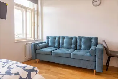 a blue couch in a living room with a window at National Museum View Studio in Prague