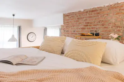 a bedroom with a white bed and a brick wall at Prague Days - Studio with Netflix and Apple TV next to Park in Lesser Town in Prague
