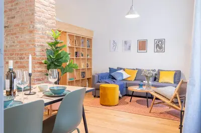 a living room with a blue couch and a table at Prague Days - Studio with Netflix and Apple TV next to Park in Lesser Town in Prague