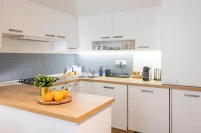 a white kitchen with a plate of oranges on a counter at Prague Days - Studio with Netflix and Apple TV next to Park in Lesser Town in Prague