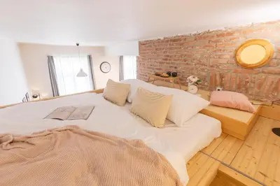 a large bed in a room with a brick wall at Prague Days - Studio with Netflix and Apple TV next to Park in Lesser Town in Prague