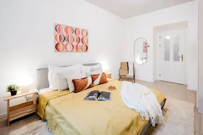 a bedroom with a large bed and a mirror at Prague Days - 3BDR Apartments with Terrace in Residential Vinohrady in Prague
