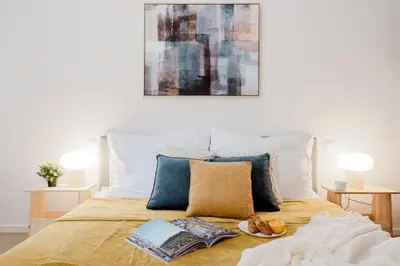 a bed with two books and a plate of food on it at Prague Days - 3BDR Apartments with Terrace in Residential Vinohrady in Prague