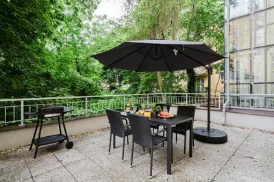 a table with chairs and an umbrella on a balcony at Prague Days - 3BDR Apartments with Terrace in Residential Vinohrady in Prague