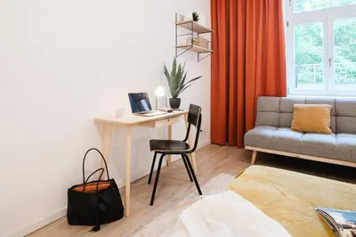 a room with a desk with a laptop and a chair at Prague Days - 3BDR Apartments with Terrace in Residential Vinohrady in Prague