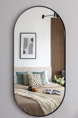 a mirror hanging on a wall next to a bed at Prague Days - Modern Apartment with Terrace and AC in Karlín in Prague