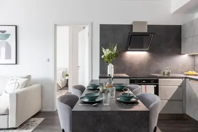 a kitchen with a table and chairs in a kitchen at Prague Days - Modern Apartment with Terrace and AC in Karlín in Prague