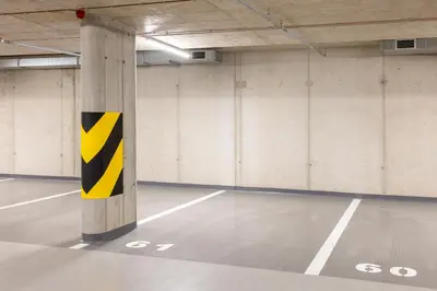 an empty parking garage with a yellow and black pole at Prague Days - Modern Apartment with Terrace and AC in Karlín in Prague