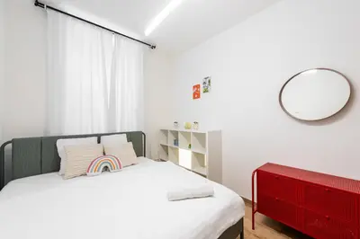 a bedroom with a bed with a red dresser and a mirror at Milano Apartment in Prague