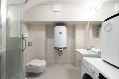 a white bathroom with a toilet and a sink at Milano Apartment in Prague