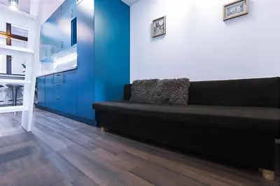 a black couch in a room with a blue wall at Charming Apartment in Historic Old Town in Prague