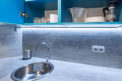 a sink in a kitchen with a blue cabinet at Charming Apartment in Historic Old Town in Prague