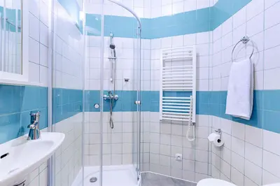 a blue and white bathroom with a shower and a sink at Charming Apartment in Historic Old Town in Prague