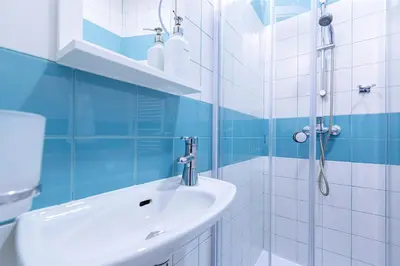 a blue and white bathroom with a sink and a shower at Charming Apartment in Historic Old Town in Prague